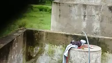 Indian village girl bathing near water tank outdoor
